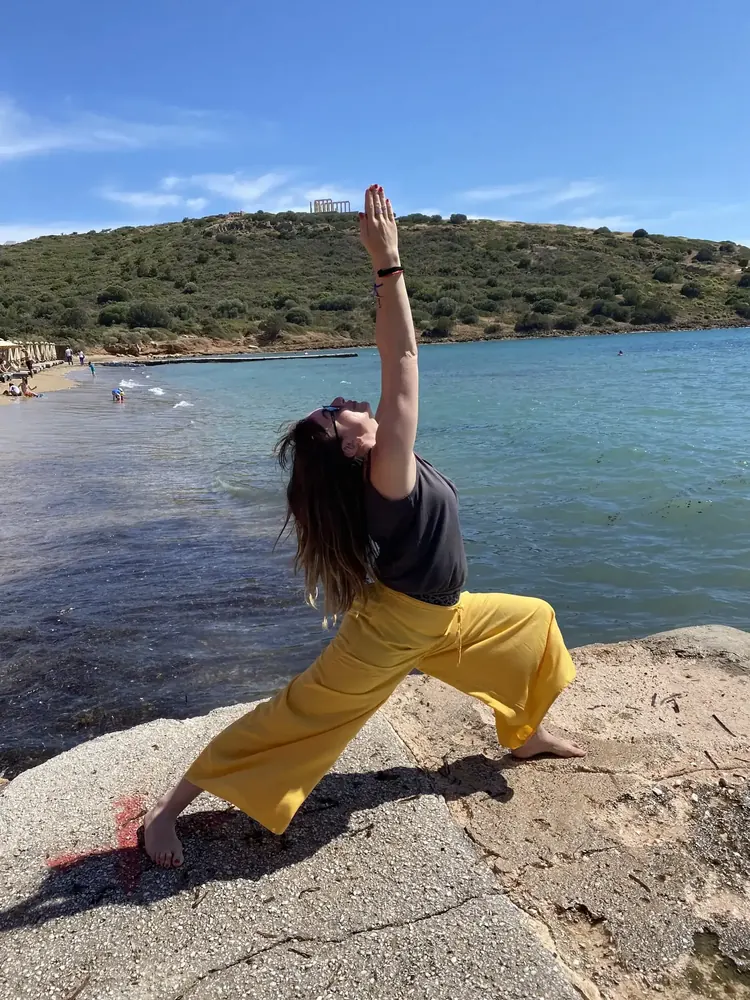 Η Μιράντα Κοροβίλα σε στάση γιόγκα δίπλα στη θάλασσα.