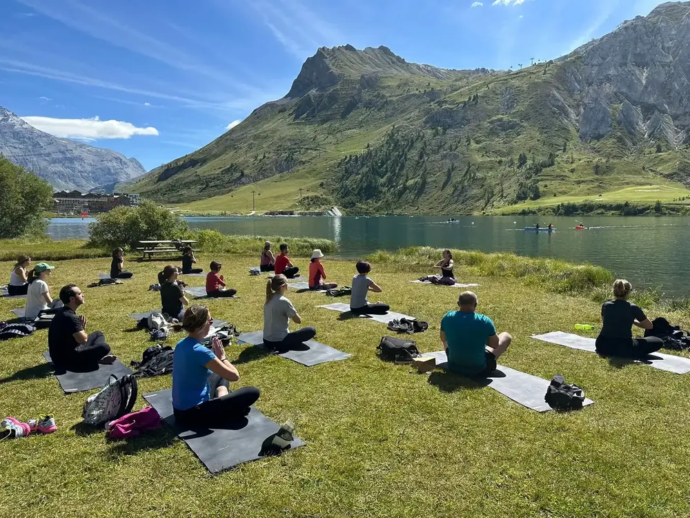 Ομαδική πρακτική yoga δίπλα σε λίμνη στα βουνά, σε ένα από τα ταξίδια μας.